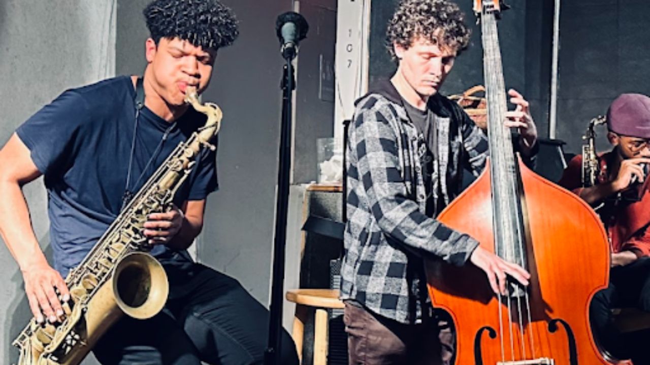 Jazz musicians performing live in an intimate venue, featuring a saxophonist and upright bass player during a small ensemble set.