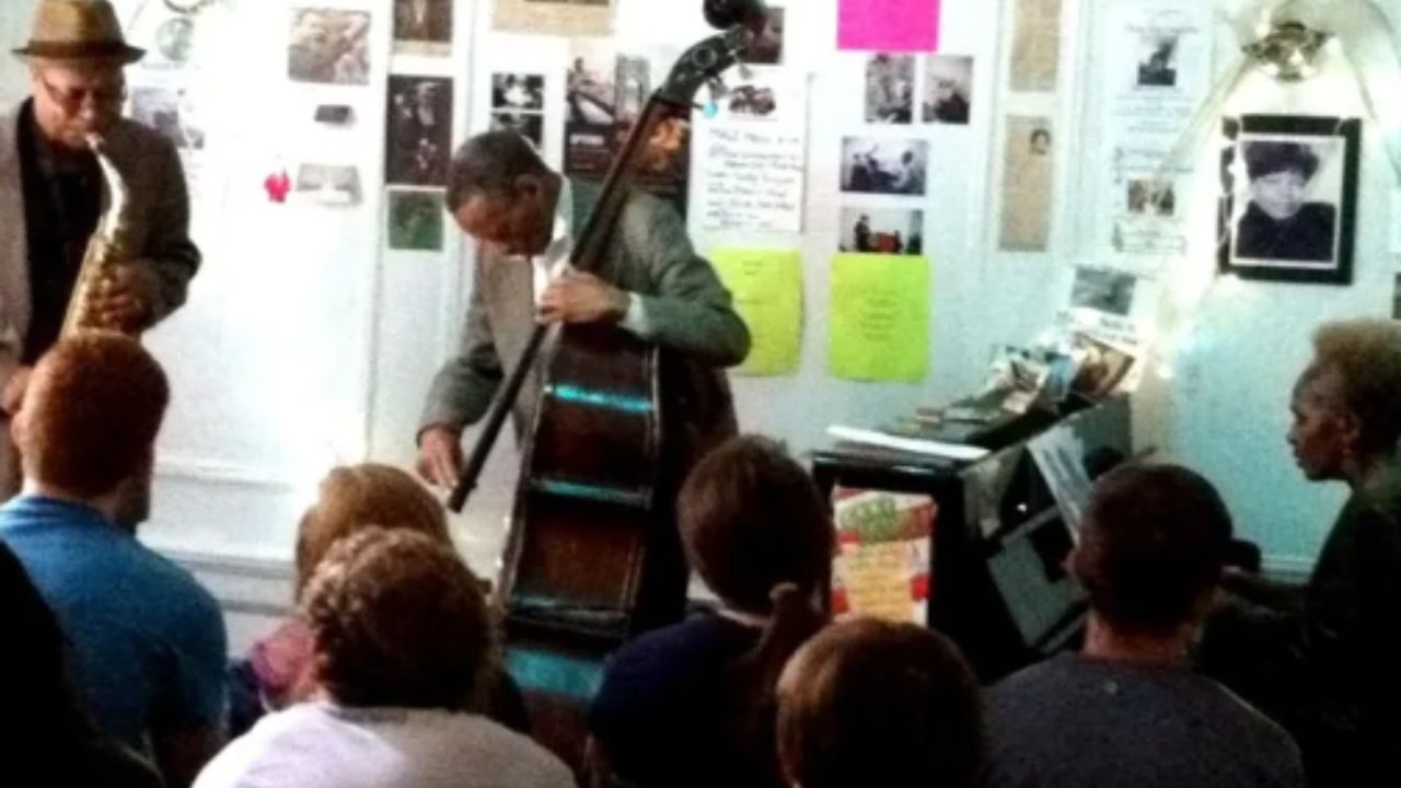 Live jazz performance in an intimate NYC venue, with musicians playing saxophone and upright bass