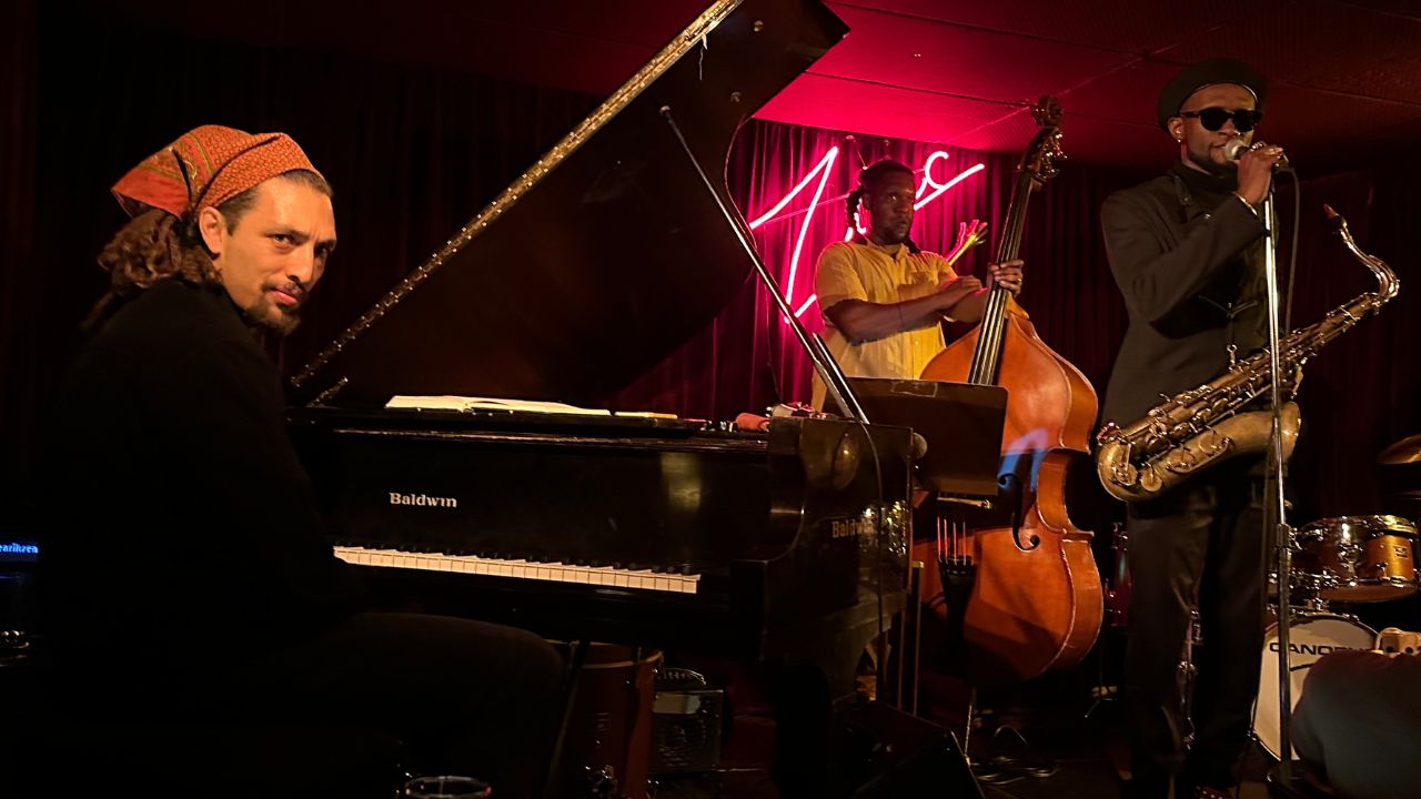 Mathis Picard plays piano and saxophone in front of a band, showcasing his musical talent and engaging with the audience.