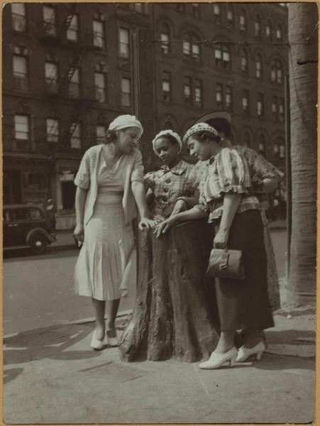 a group of people standing on a sidewalk